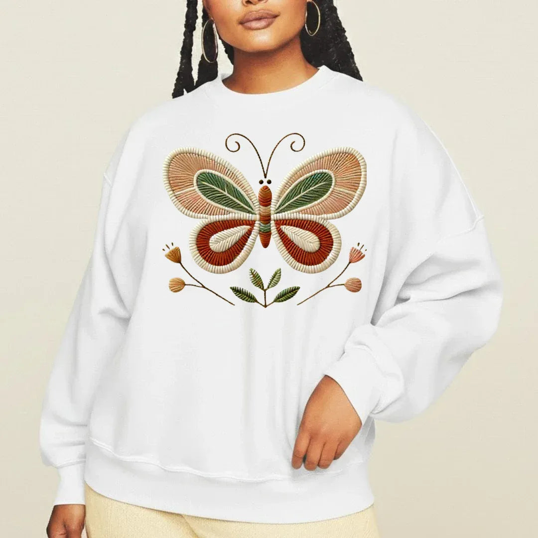 Close up of folk butterfly faux embroidery print on white crewneck sweatshirt — stitched look design