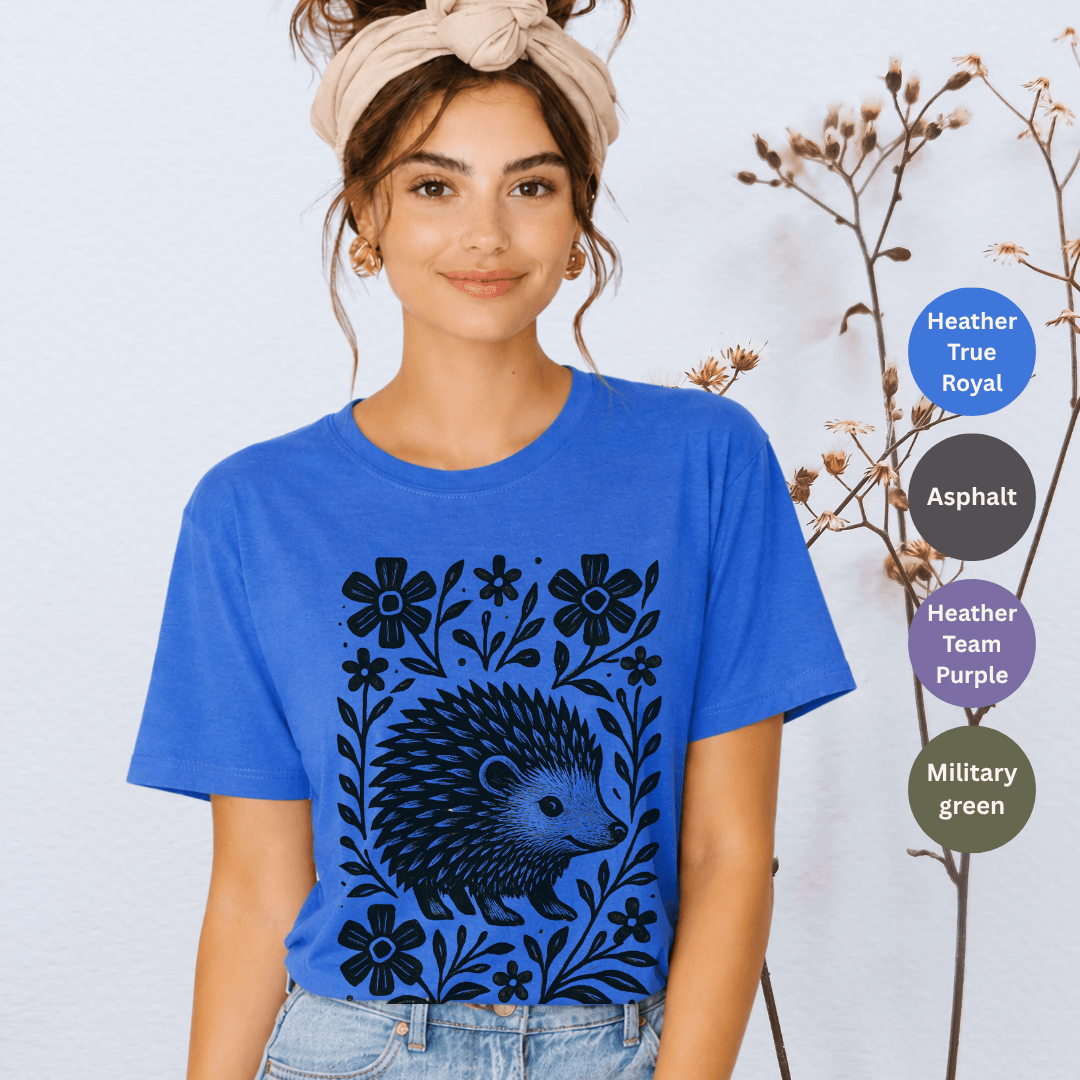 Heather true royal Bella+Canvas 3001 t-shirt with folk hedgehog linocut graphic and floral frame in black ink